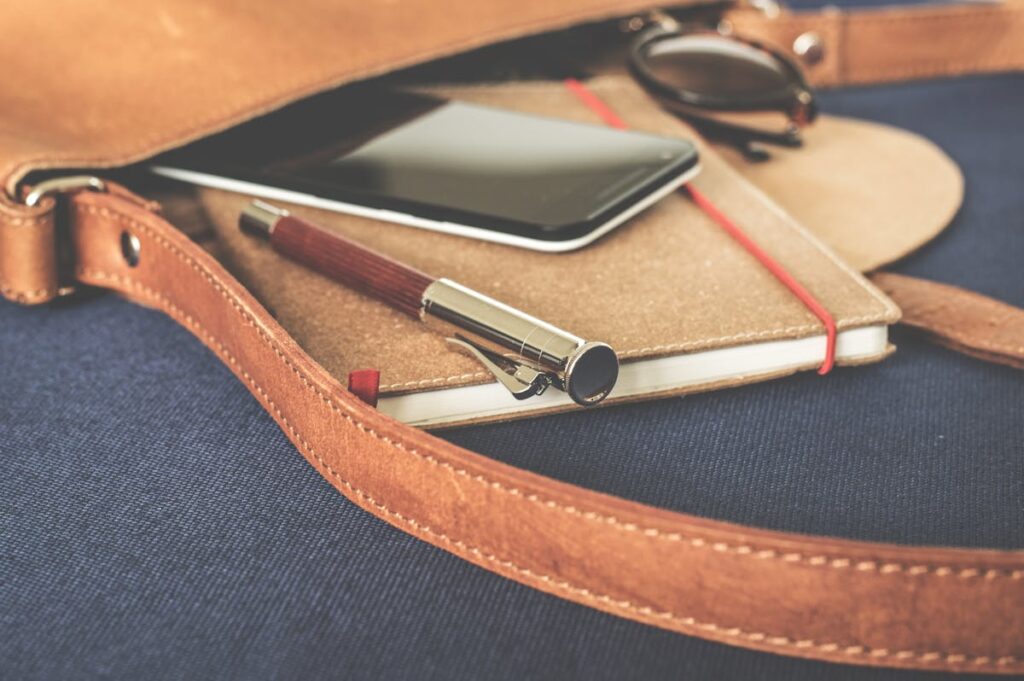 Notizbuch und Smartphone in Ledertasche