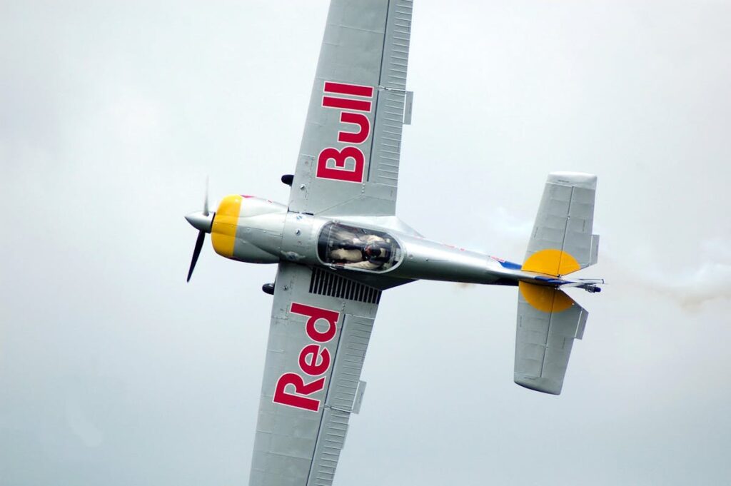 Flugzeug mit Red Bull-Logo in der Luft.