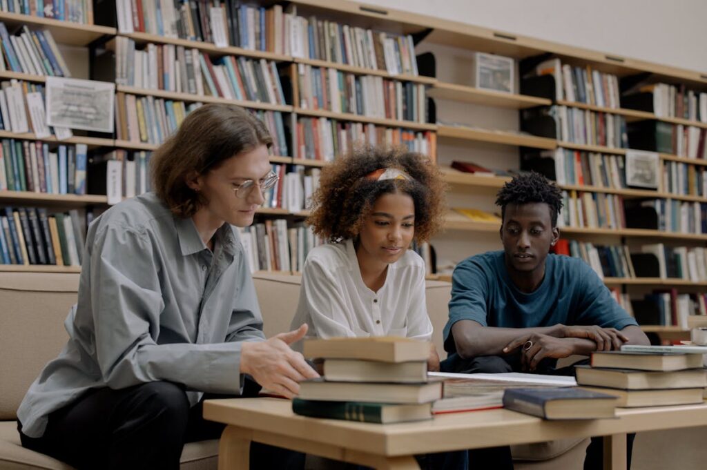 Interkultureller Content wird von einer Gruppe Menschen verschiedener Herkunft in einer Bibliothek konsumiert.