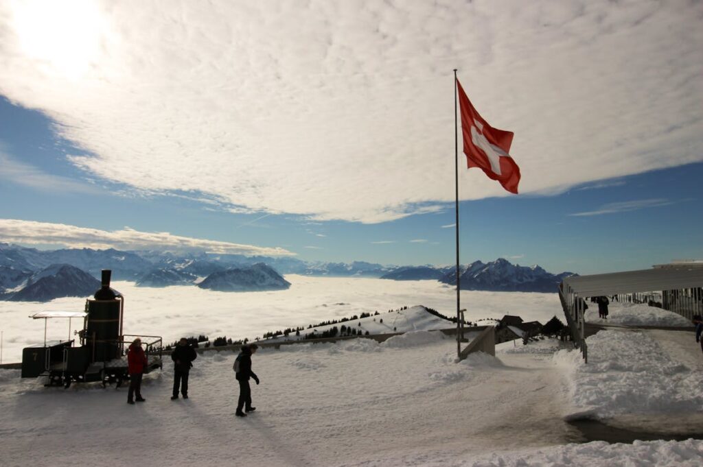 Schweizer Flagge vor Bergpanorama.