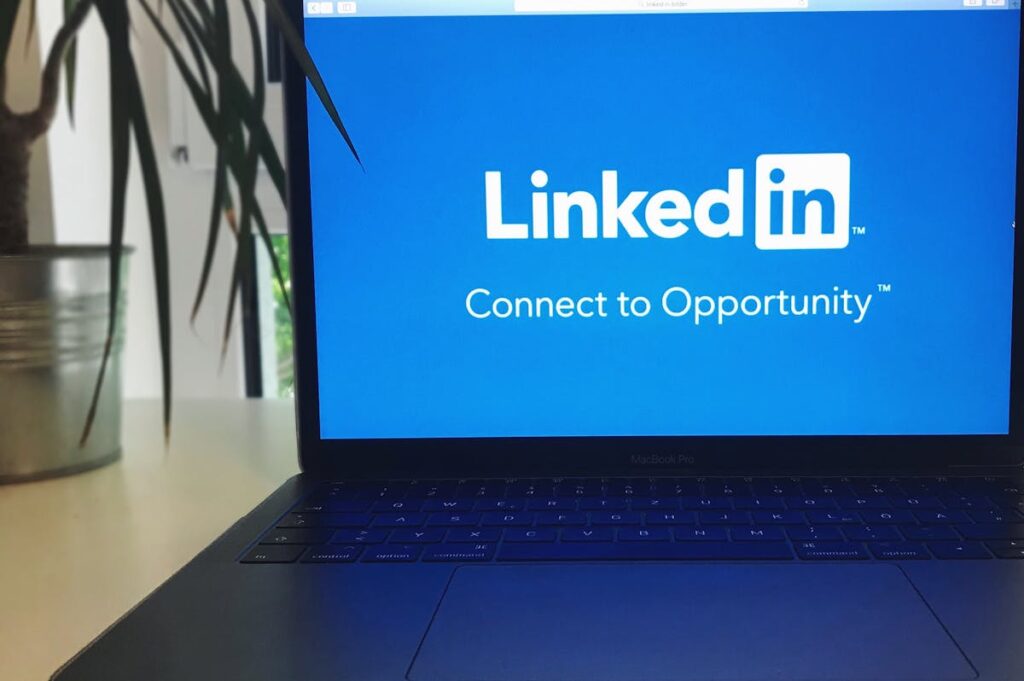 Laptop mit LinkedIn-Logo auf Tisch.